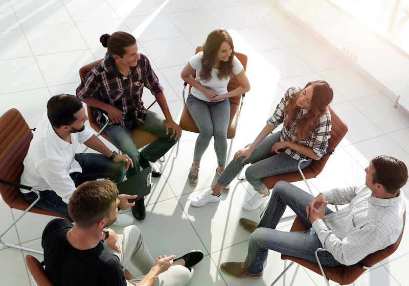 a group of people in a circle, talking
